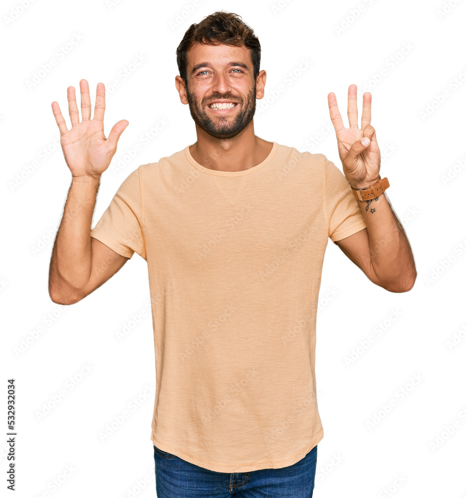 Handsome young man with beard wearing casual tshirt showing and pointing up with fingers number eight while smiling confident and happy. Handsome young man with beard wearing casual tshirt showing and pointing up with fingers number eight while smiling confident and happy.
