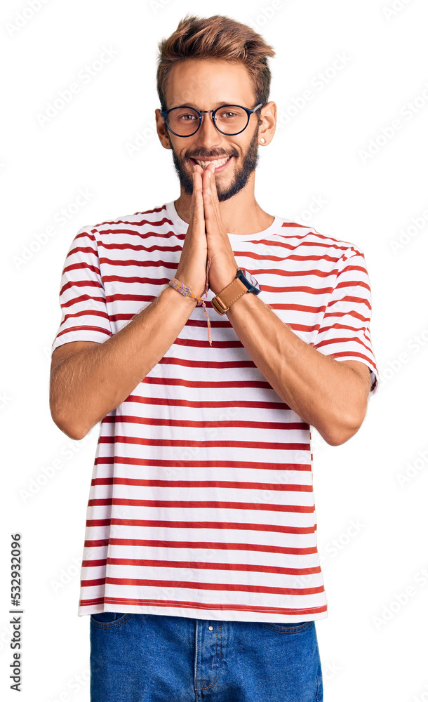 Handsome blond man with beard wearing casual clothes and glasses praying with hands together asking for forgiveness smiling confident. Handsome blond man with beard wearing casual clothes and glasses praying with hands together asking for forgiveness smiling confident.