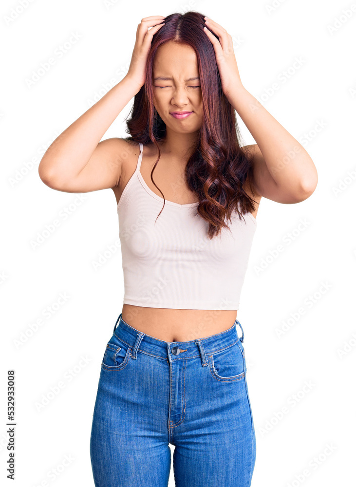 Fototapeta premium Young beautiful chinese girl wearing casual clothes suffering from headache desperate and stressed because pain and migraine. hands on head.