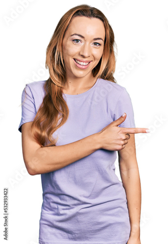 Young caucasian woman wearing casual clothes smiling cheerful pointing with hand and finger up to the side