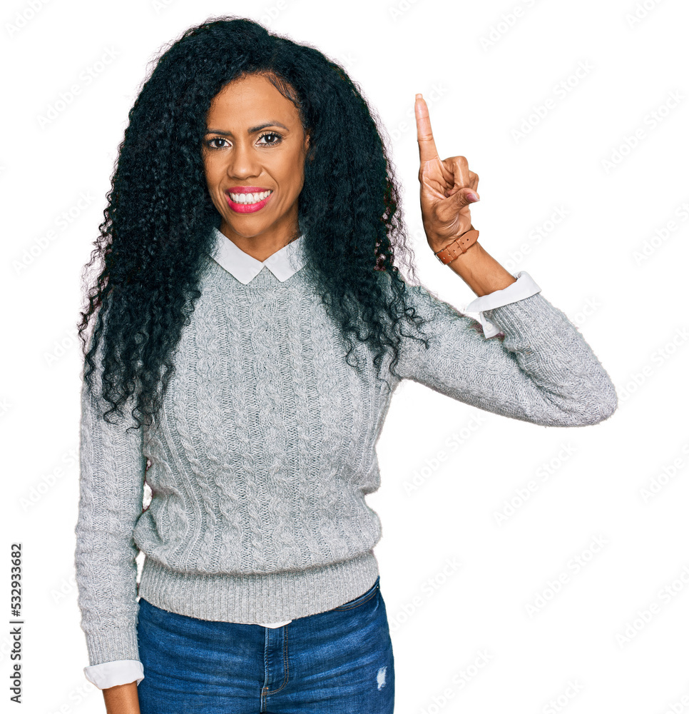 Middle age african american woman wearing casual clothes pointing finger up with successful idea. exited and happy. number one. Middle age african american woman wearing casual clothes pointing finger up with successful idea. exited and happy. number one.