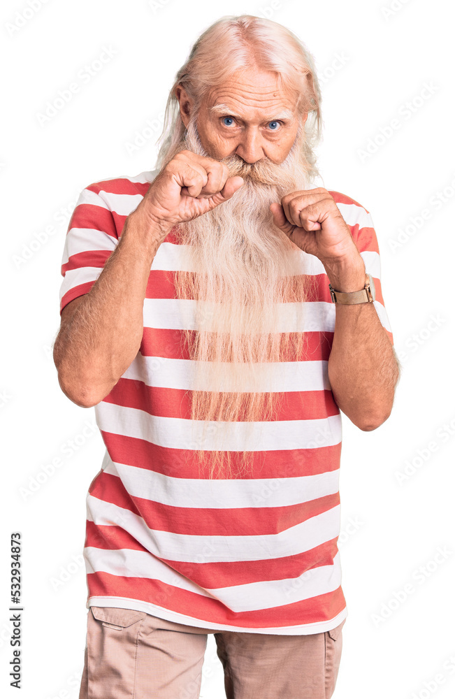 Old senior man with grey hair and long beard wearing striped tshirt ready to fight with fist defense gesture, angry and upset face, afraid of problem Old senior man with grey hair and long beard wearing striped tshirt ready to fight with fist defense gesture, angry and upset face, afraid of problem