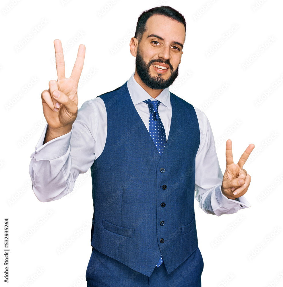 Young man with beard wearing business vest smiling looking to the camera showing fingers doing victory sign. number two. Young man with beard wearing business vest smiling looking to the camera showing fingers doing victory sign. number two.