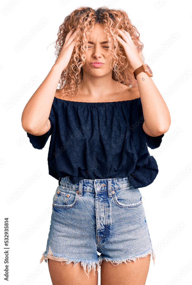 Young blonde woman with curly hair wearing casual summer clothes suffering from headache desperate and stressed because pain and migraine. hands on head. Young blonde woman with curly hair wearing casual summer clothes suffering from headache desperate and stressed because pain and migraine. hands on head.
