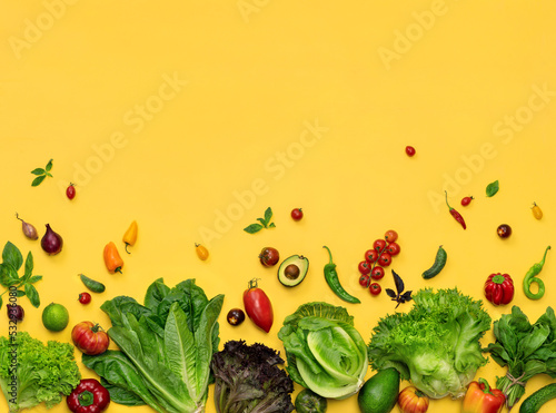 Photo of organic different lettuces and vegetables on yellow background. Top view. High resolution product