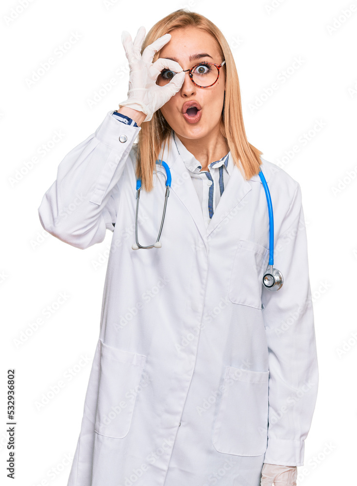 Beautiful caucasian woman wearing doctor uniform and stethoscope doing ok gesture shocked with surprised face, eye looking through fingers. unbelieving expression. Beautiful caucasian woman wearing doctor uniform and stethoscope doing ok gesture shocked with surprised face, eye looking through fingers. unbelieving expression.