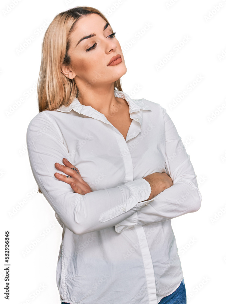 Young caucasian woman wearing casual clothes looking to the side with arms crossed convinced and confident Young caucasian woman wearing casual clothes looking to the side with arms crossed convinced and confident