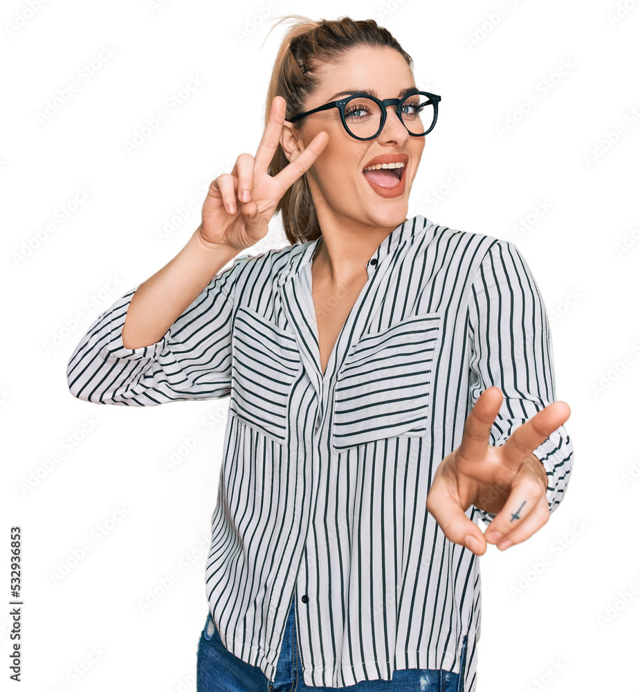 Young caucasian woman wearing business shirt and glasses smiling looking to the camera showing fingers doing victory sign. number two. Young caucasian woman wearing business shirt and glasses smiling looking to the camera showing fingers doing victory sign. number two.