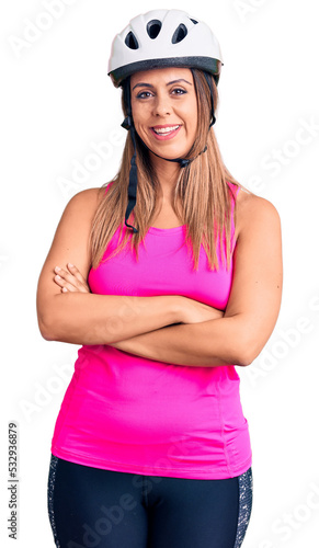 Young beautiful woman wearing bike helmet happy face smiling with crossed arms looking at the camera. positive person. © Krakenimages.com