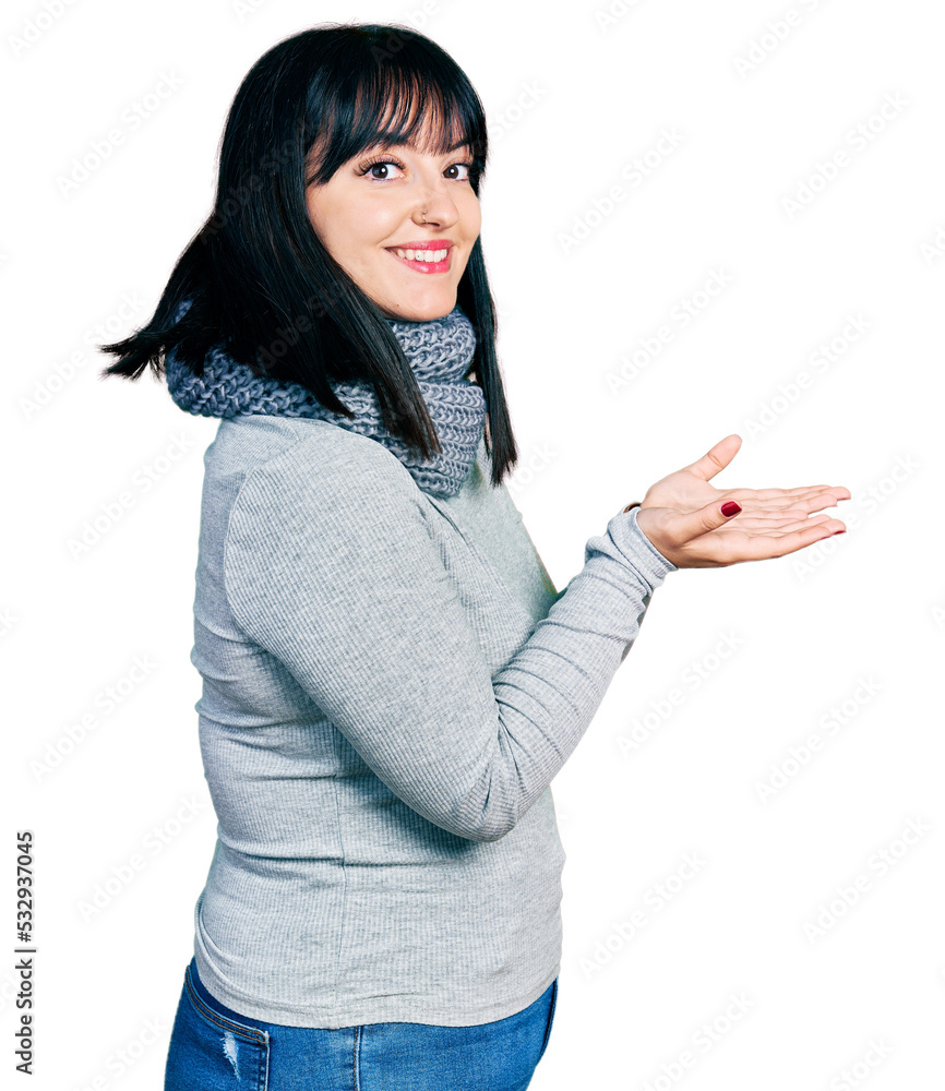 Young hispanic plus size woman wearing winter scarf pointing aside with hands open palms showing copy space, presenting advertisement smiling excited happy Young hispanic plus size woman wearing winter scarf pointing aside with hands open palms showing copy space, presenting advertisement smiling excited happy