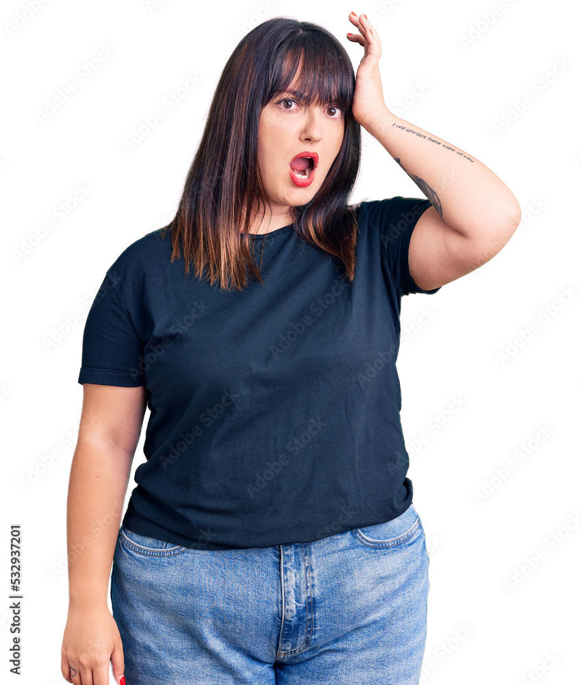 Fototapeta premium Young plus size woman wearing casual clothes surprised with hand on head for mistake, remember error. forgot, bad memory concept.