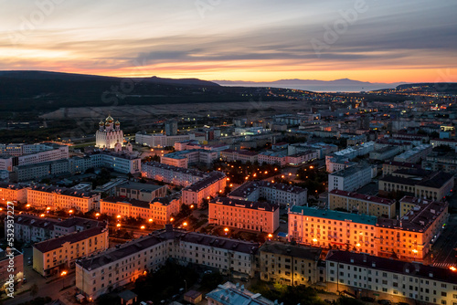 City of Magadan, Magadan region, Far East of Russia. Morning autumn aerial photograph of the northern city. Top view of the streets and buildings. In the distance is a sea bay. Early morning, dawn.