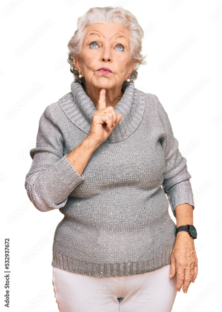 Senior grey-haired woman wearing casual winter sweater thinking concentrated about doubt with finger on chin and looking up wondering Senior grey-haired woman wearing casual winter sweater thinking concentrated about doubt with finger on chin and looking up wondering