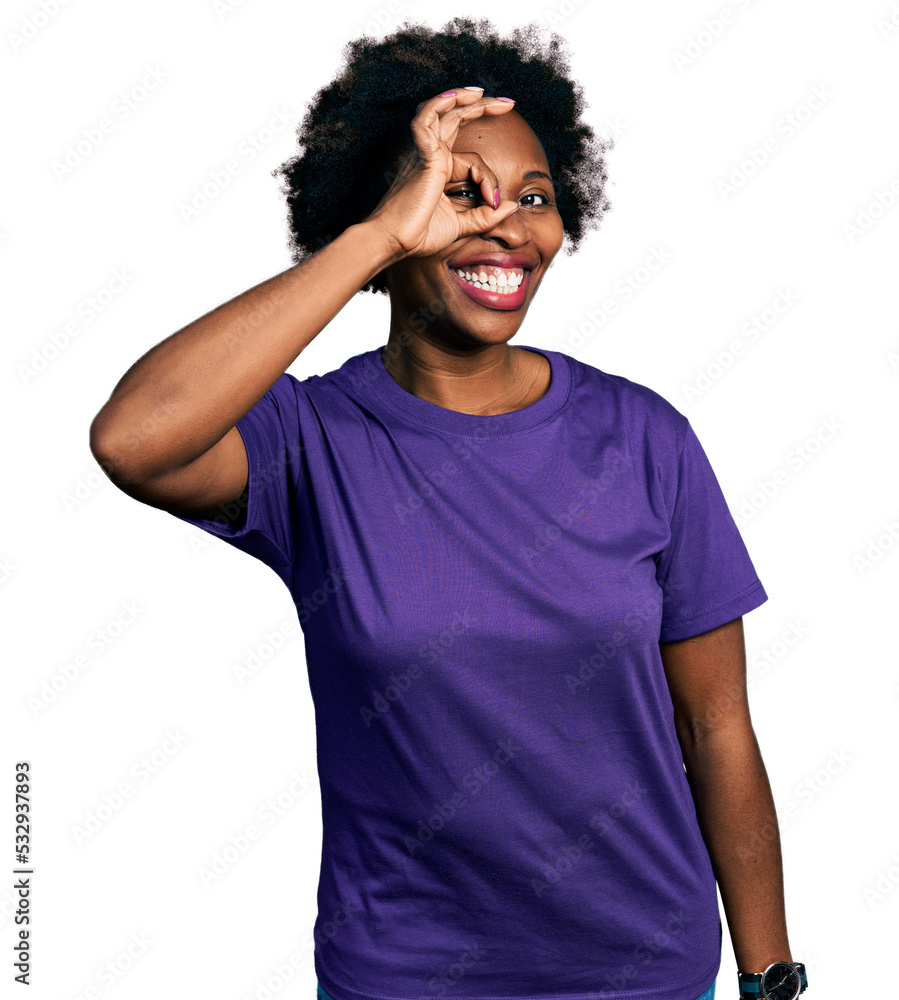 African american woman with afro hair wearing casual purple t shirt doing ok gesture with hand smiling, eye looking through fingers with happy face. African american woman with afro hair wearing casual purple t shirt doing ok gesture with hand smiling, eye looking through fingers with happy face.