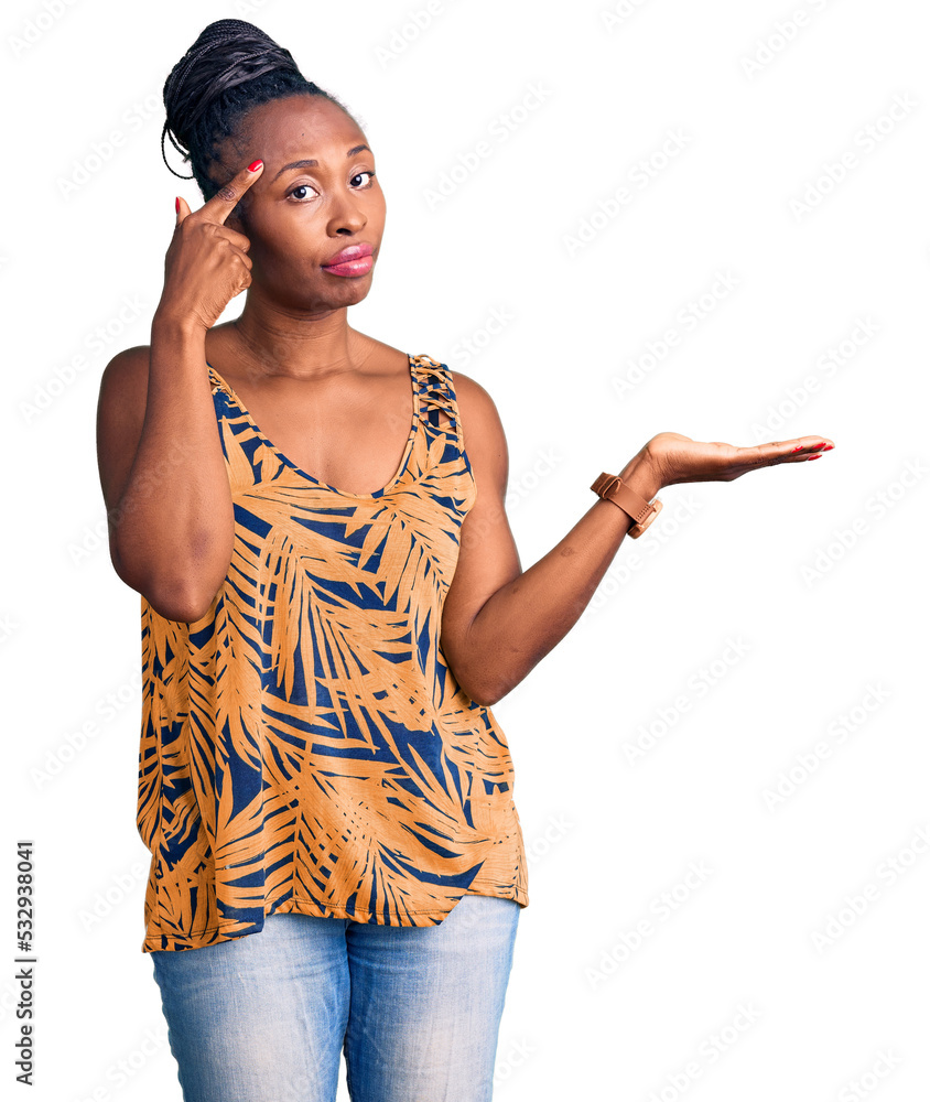 Young african american woman wearing casual clothes confused and annoyed with open palm showing copy space and pointing finger to forehead. think about it. Young african american woman wearing casual clothes confused and annoyed with open palm showing copy space and pointing finger to forehead. think about it.