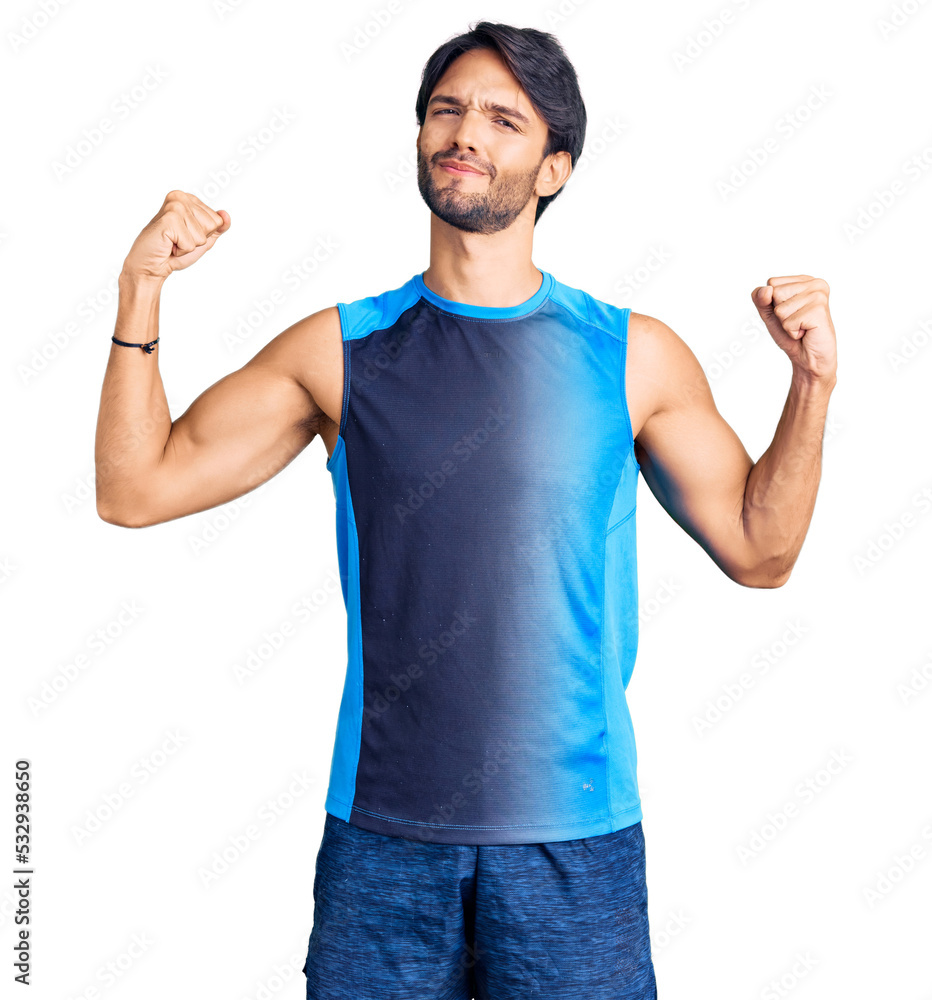 Handsome hispanic man wearing sportswear showing arms muscles smiling proud. fitness concept. Handsome hispanic man wearing sportswear showing arms muscles smiling proud. fitness concept.
