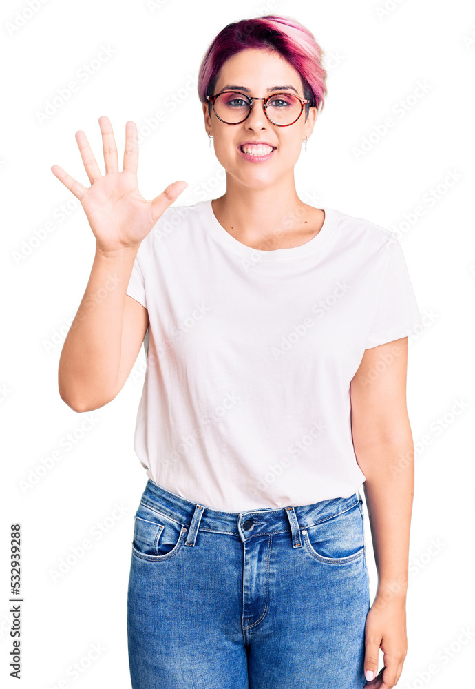 Young beautiful woman with pink hair wearing casual clothes and glasses showing and pointing up with fingers number five while smiling confident and happy. Young beautiful woman with pink hair wearing casual clothes and glasses showing and pointing up with fingers number five while smiling confident and happy.