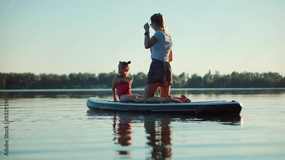 Mother With Daughter Floating On Sup Board. Family Relationship Recreation On Daughter. Kid Children Girl Happy With Mom. Carefree Childhood Summer Family Fun. Infant Relationship Cheerful Parent Mother With Daughter Floating On Sup Board. Family Relationship Recreation On Daughter. Kid Children Girl Happy With Mom. Carefree Childhood Summer Family Fun. Infant Relationship Cheerful Parent
