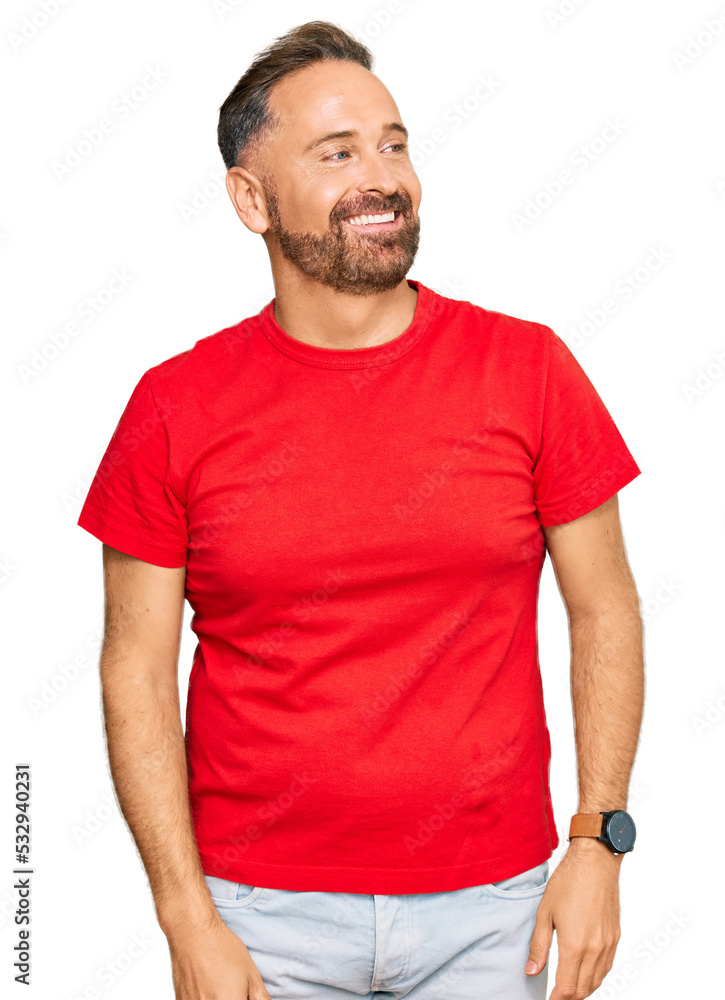 Fototapeta premium Handsome middle age man wearing casual red tshirt looking away to side with smile on face, natural expression. laughing confident.