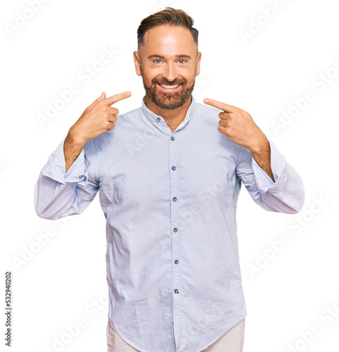 Handsome middle age man wearing business shirt smiling cheerful showing and pointing with fingers teeth and mouth. dental health concept.