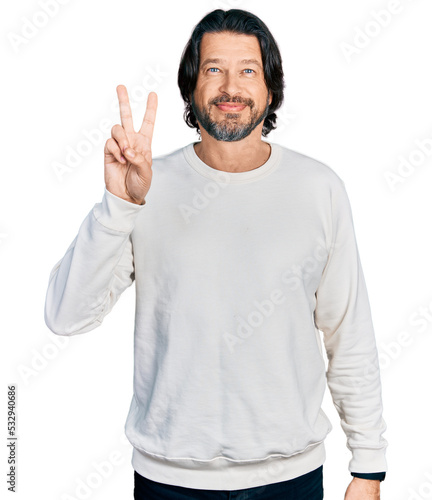 Middle age caucasian man wearing casual clothes showing and pointing up with fingers number two while smiling confident and happy. © Krakenimages.com