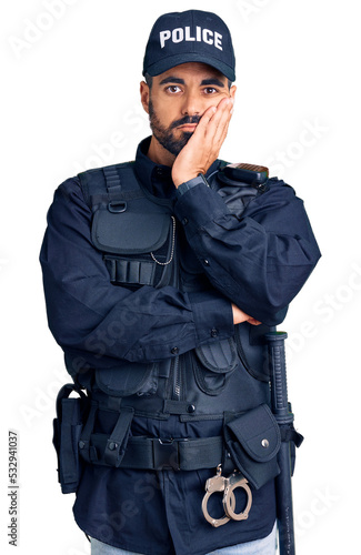 Young hispanic man wearing police uniform thinking looking tired and bored with depression problems with crossed arms. © Krakenimages.com