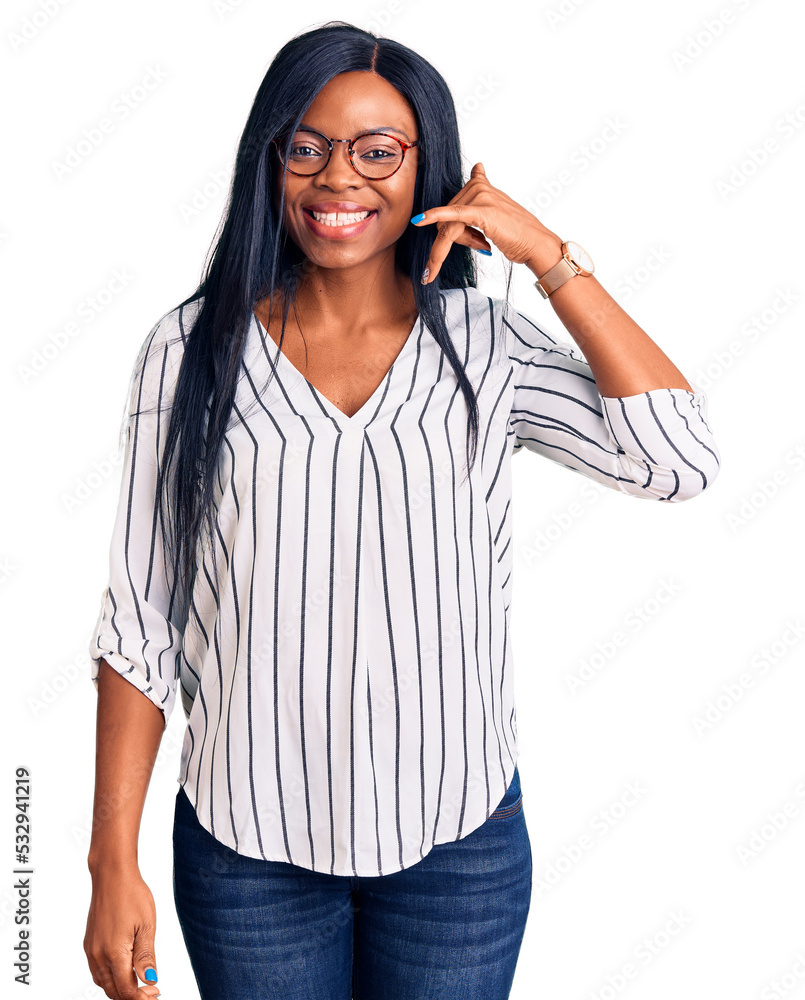 Young african american woman wearing casual clothes and glasses smiling doing phone gesture with hand and fingers like talking on the telephone. communicating concepts. Young african american woman wearing casual clothes and glasses smiling doing phone gesture with hand and fingers like talking on the telephone. communicating concepts.