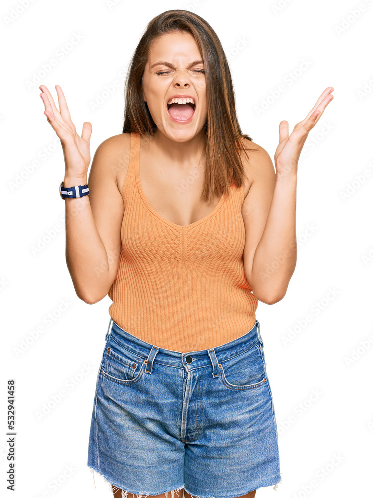Young caucasian woman wearing casual clothes celebrating mad and crazy for success with arms raised and closed eyes screaming excited. winner concept Young caucasian woman wearing casual clothes celebrating mad and crazy for success with arms raised and closed eyes screaming excited. winner concept