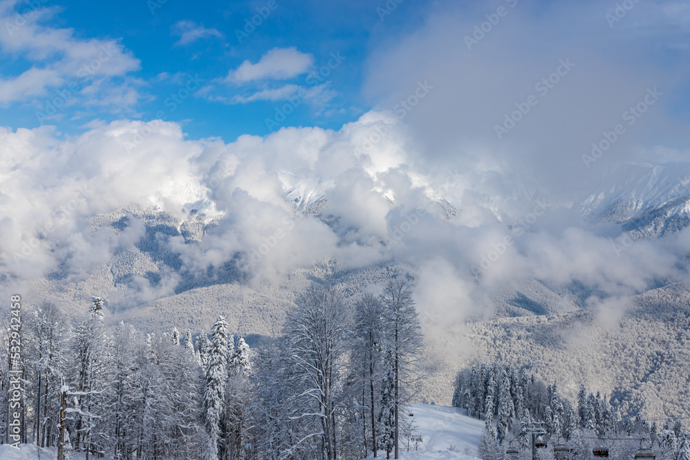 SOCHI, RUSSIA - JANUARY 25, 2022: Panoramic view of ski lift with ski slopes and mountain background in Rosa Khutor ski resort.