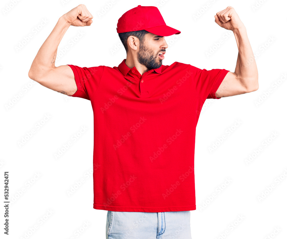 Young handsome man with beard wearing delivery uniform showing arms muscles smiling proud. fitness concept.