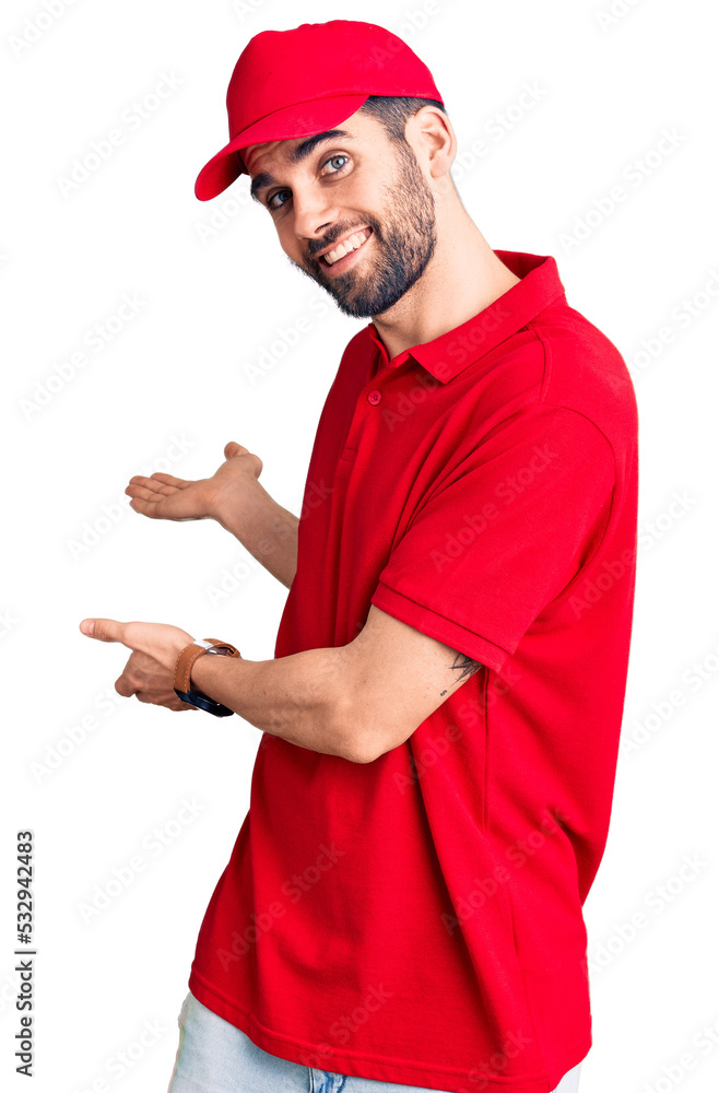 Young handsome man with beard wearing delivery uniform inviting to enter smiling natural with open hand Young handsome man with beard wearing delivery uniform inviting to enter smiling natural with open hand