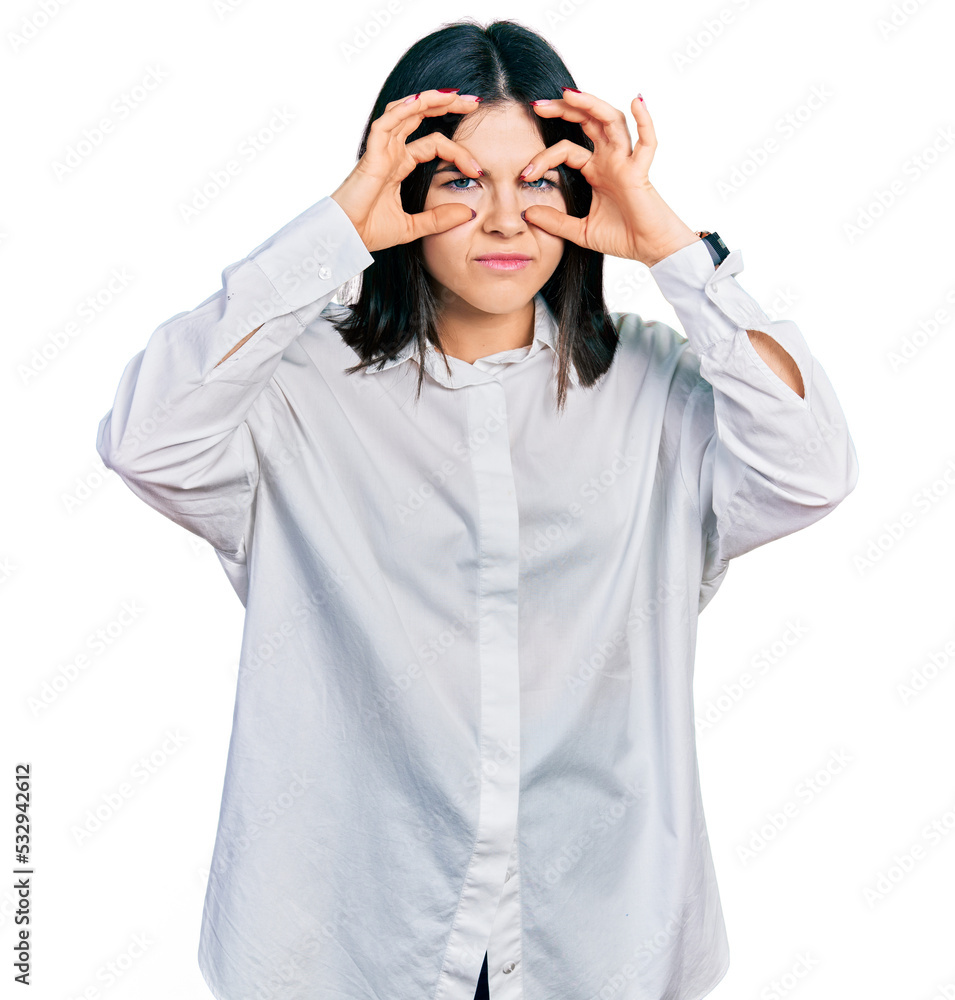 Young brunette woman with blue eyes wearing oversize white shirt trying to open eyes with fingers, sleepy and tired for morning fatigue Young brunette woman with blue eyes wearing oversize white shirt trying to open eyes with fingers, sleepy and tired for morning fatigue