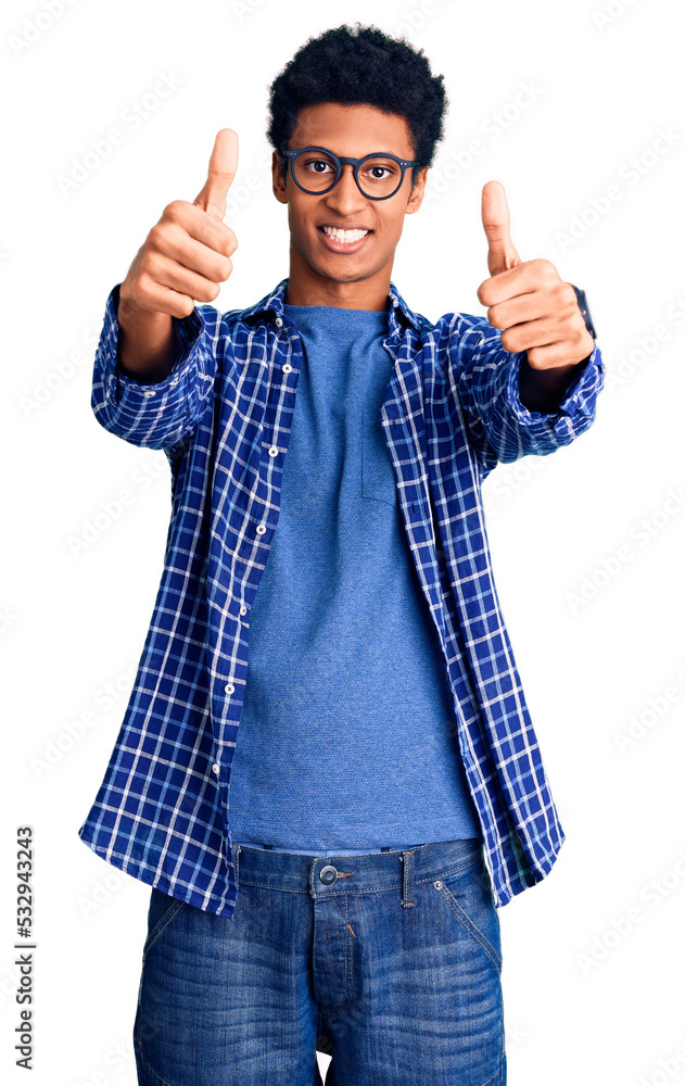 Young african american man wearing casual clothes and glasses approving doing positive gesture with hand, thumbs up smiling and happy for success. winner gesture. Young african american man wearing casual clothes and glasses approving doing positive gesture with hand, thumbs up smiling and happy for success. winner gesture.