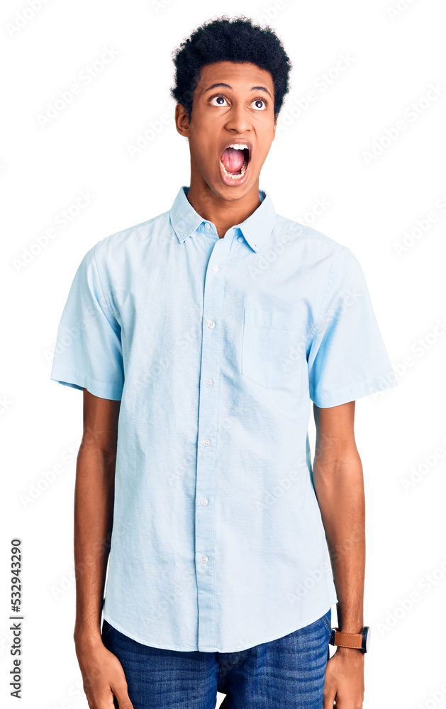 Young african american man wearing casual clothes angry and mad screaming frustrated and furious, shouting with anger. rage and aggressive concept. Young african american man wearing casual clothes angry and mad screaming frustrated and furious, shouting with anger. rage and aggressive concept.