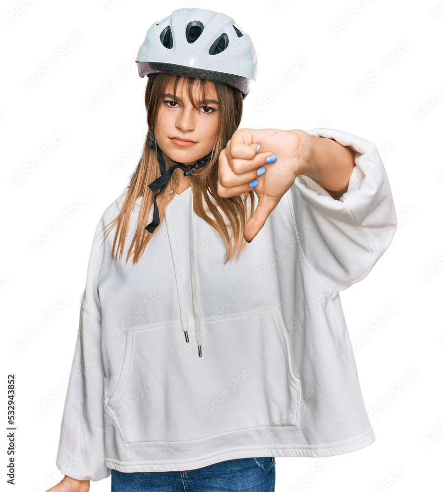 Teenager caucasian girl wearing bike helmet looking unhappy and angry showing rejection and negative with thumbs down gesture. bad expression. Teenager caucasian girl wearing bike helmet looking unhappy and angry showing rejection and negative with thumbs down gesture. bad expression.