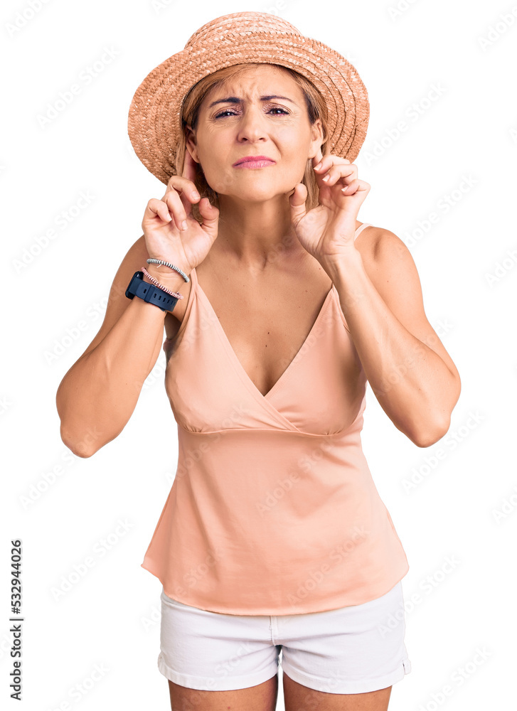 Young blonde woman wearing summer hat trying to hear both hands on ear gesture, curious for gossip. hearing problem, deaf Young blonde woman wearing summer hat trying to hear both hands on ear gesture, curious for gossip. hearing problem, deaf