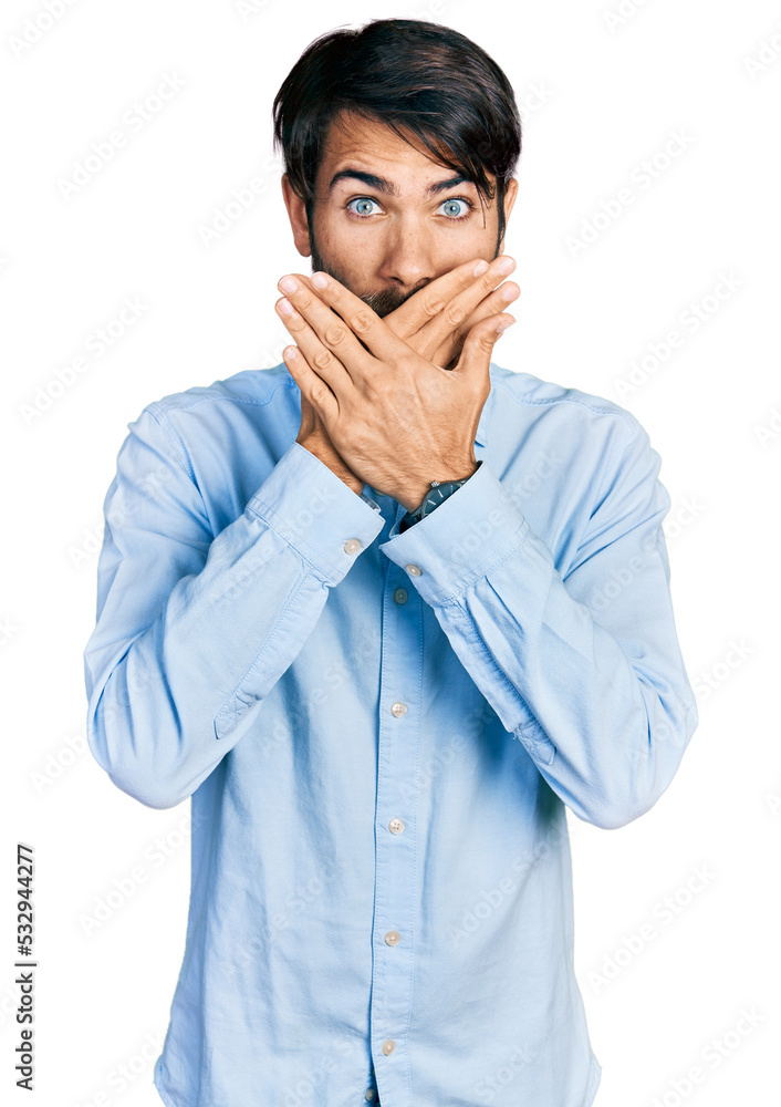 Hispanic man with blue eyes wearing business shirt shocked covering mouth with hands for mistake. secret concept. Hispanic man with blue eyes wearing business shirt shocked covering mouth with hands for mistake. secret concept.