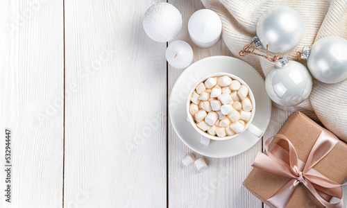 Christmas composition with coffee with marshmallows, a gift and Christmas decorations. The concept of Christmas, New Year. Top view, copy space