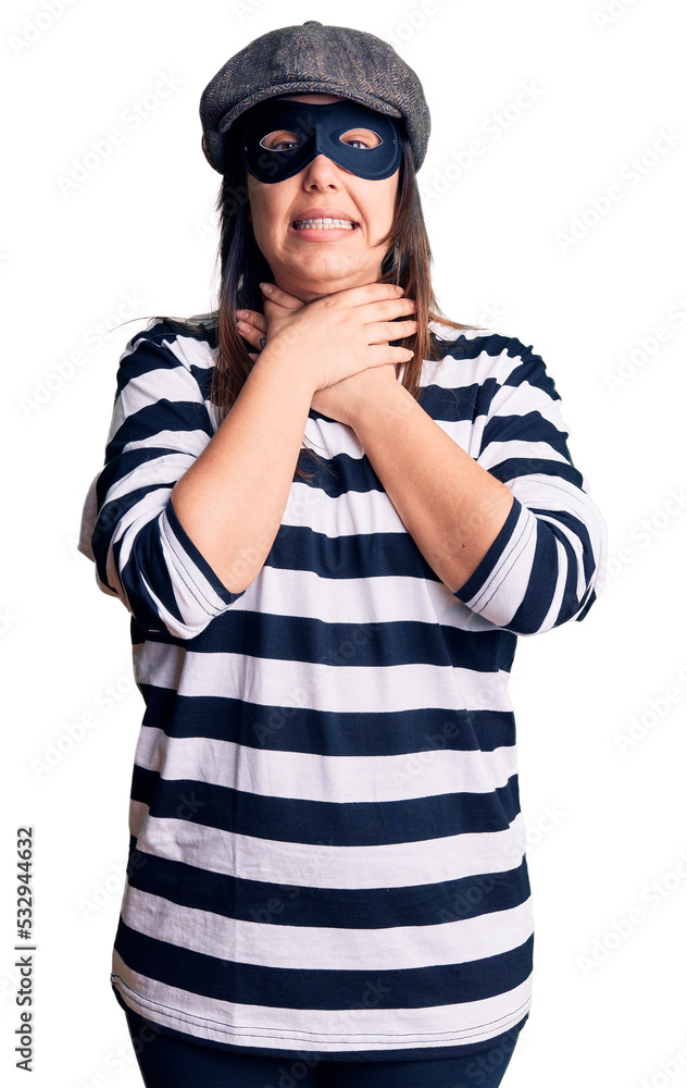 Young beautiful brunette woman wearing burglar mask shouting and suffocate because painful strangle. health problem. asphyxiate and suicide concept. Young beautiful brunette woman wearing burglar mask shouting and suffocate because painful strangle. health problem. asphyxiate and suicide concept.