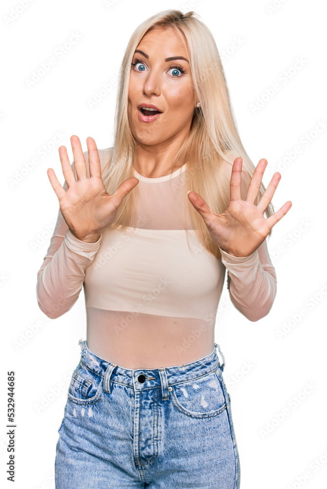 Young blonde woman wearing casual clothes afraid and terrified with fear expression stop gesture with hands, shouting in shock. panic concept. Young blonde woman wearing casual clothes afraid and terrified with fear expression stop gesture with hands, shouting in shock. panic concept.