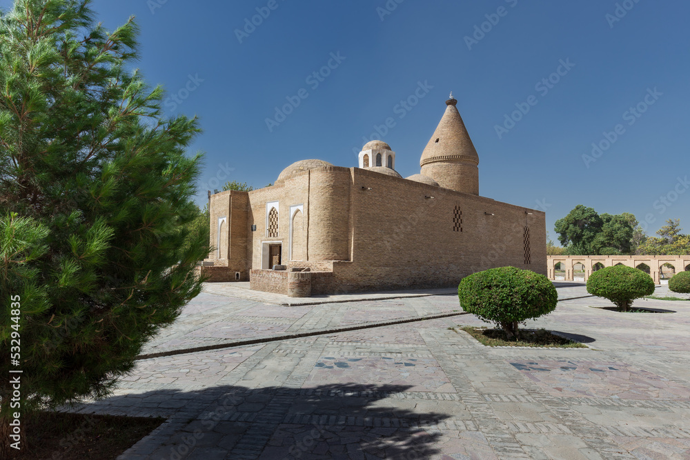 Fototapeta premium Ancient heritage Chashma-Ayub Mausoleum with conical dome surrounded by trees, Bukhara, Uzbekistan
