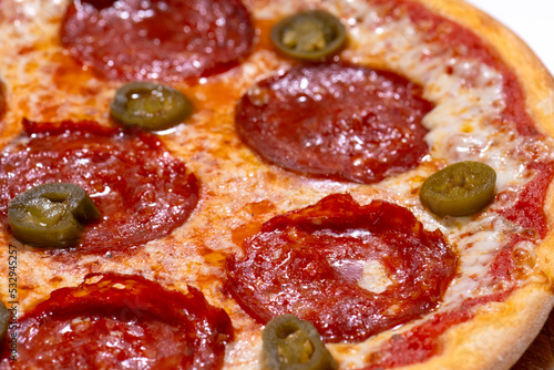 Closeup of pizza with pepperoni and jalapeno pepper