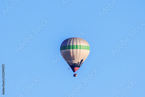 A colorful hot air balloon in the morning blue sky over the city of Augsburg