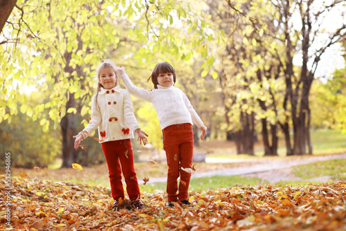 Young family on a walk in the autumn park on a sunny day. Happiness to be together. © alexkich