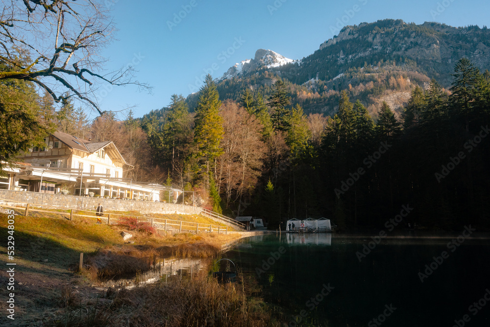 Blausee , beautiful turquoise lake and Blausee Hotel and Spa in  Kandergrund during autumn , winter morning : Blausee , Switzerland : December 4 , 2019