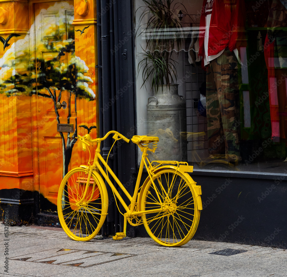 Yellow painted old bicycle beside the shop window, Michael Street,Waterford, Ireland