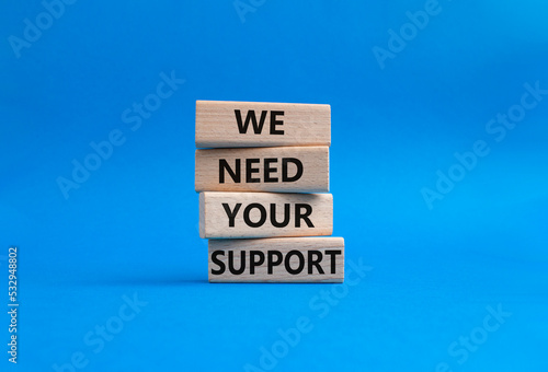 We need your support symbol. Wooden blocks with words We need your support. Beautiful blue background. Business and We need your support concept. Copy space.