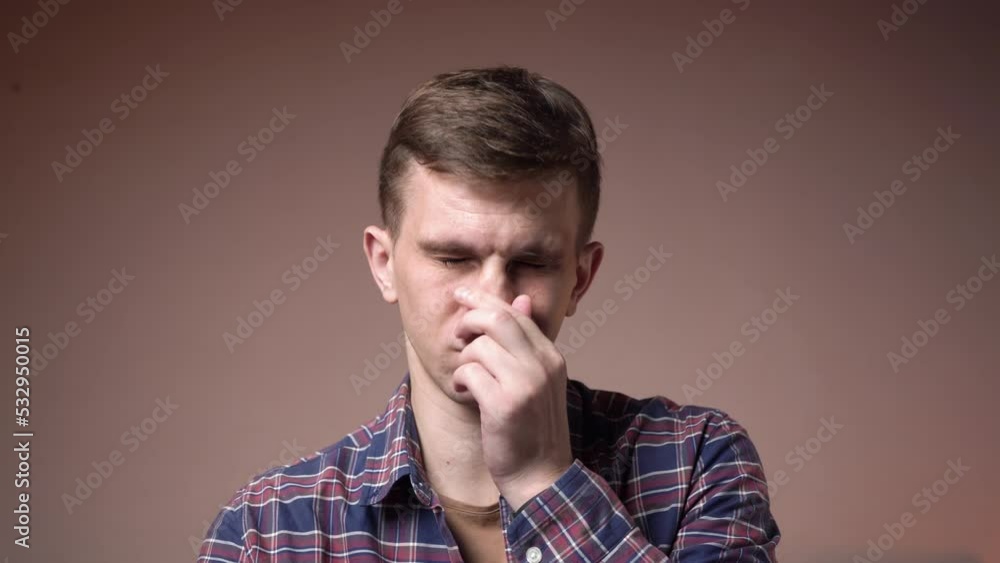 Tired young man massages his head. migraine. close-up. Tired young man massages his head. migraine. close-up.
