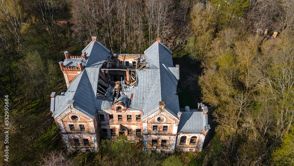 Old brick abandoned manor in the forest. Beautiful top view of an abandoned building. House with the ghosts. Ancient architecture.