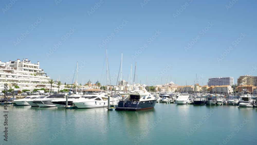 Vilamoura, PORTUGAL: September 18 2022: View of luxury port of Vilamoura - Algarve. Luxury travel destination in South of Portugal. Yacht docked, restaurants, luxury hotels, urbanisations. Pan right. Vilamoura, PORTUGAL: September 18 2022: View of luxury port of Vilamoura - Algarve. Luxury travel destination in South of Portugal. Yacht docked, restaurants, luxury hotels, urbanisations. Pan right.